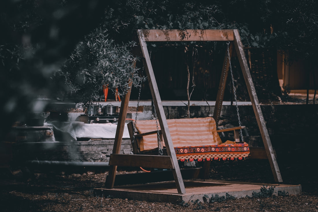 a swing chair sitting in the middle of a yard